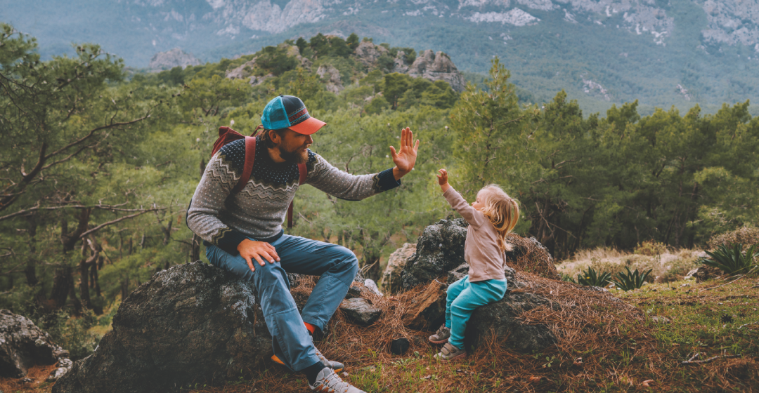 Vater und Tochter geben sich ein high five, nachdem sie das Ziel der Wanderung erreicht haben