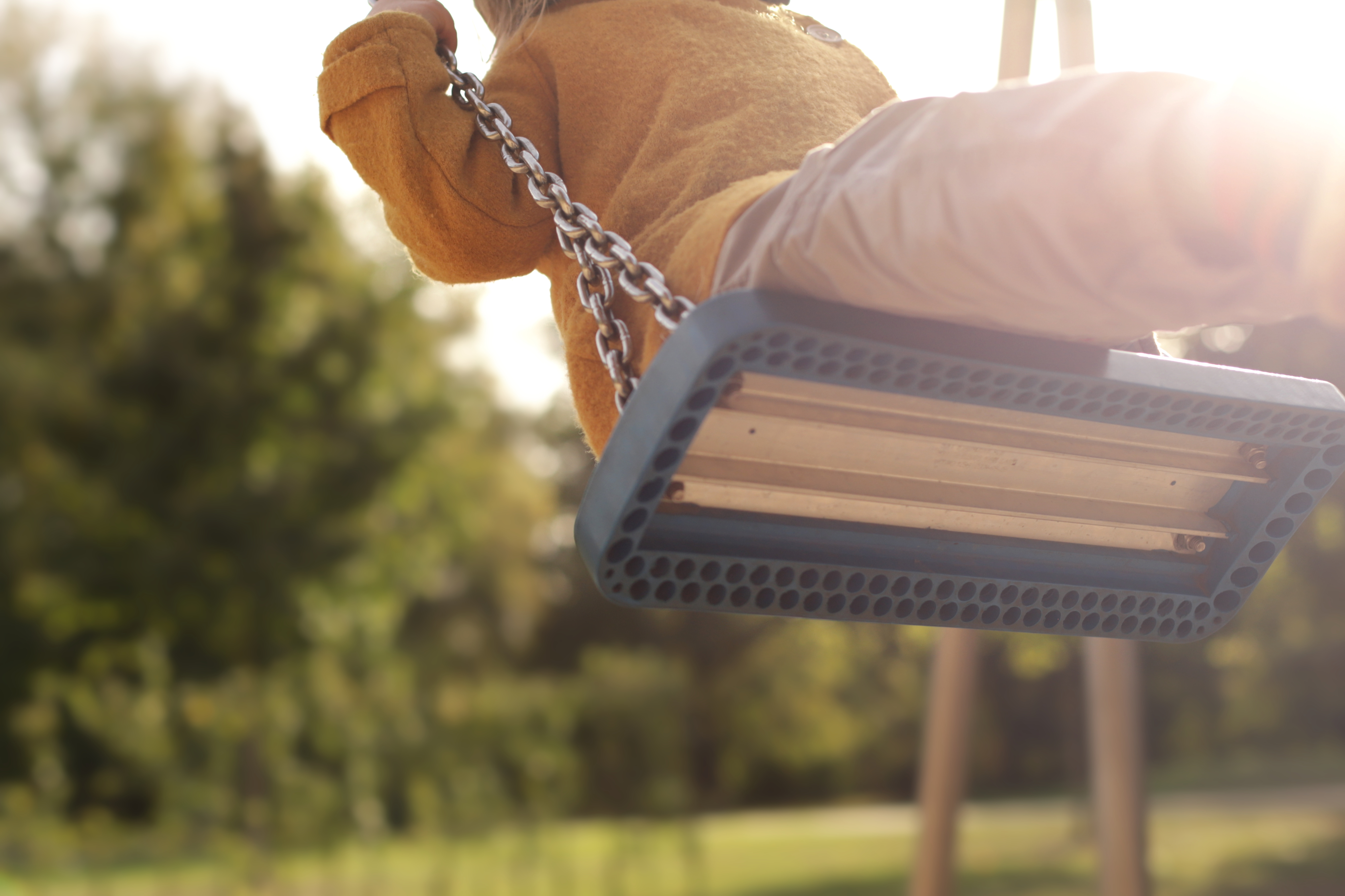 Kinder schaukeln auf dem Spielplatz